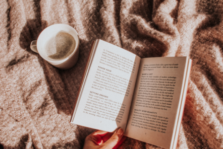 photo of an open book with coffee on a blanket the perfect reading accessories