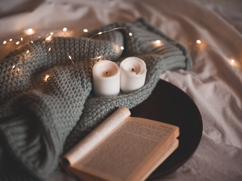 photo of blanket with candles and fairy lights on a tray with a book for new book releases November 2024