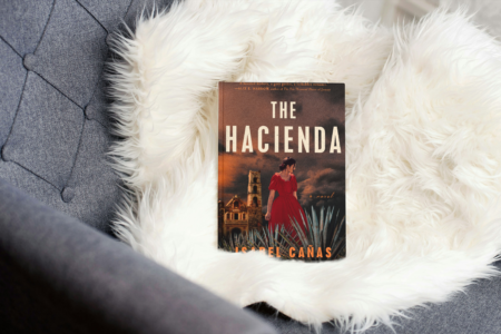 photo of book the hacienda by Isabel Cañas on a fluffy white throw on a chair