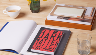 photo of book dark matter by Blake Crouch on a desk with a notebook and miscellaneous accessories