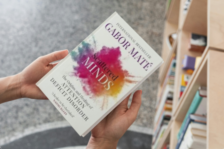 photo of person holding book scattered minds by Gabor Maté