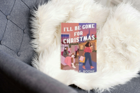 photo of book I'll be gone for christmas by Georgia k. Boone on a couch with a white fluffy throw blanket