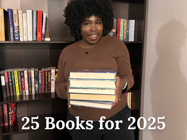 photo of kathleen haagenson holding a stack of books standing in front of two bookshelves